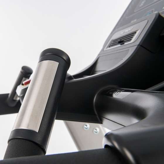 Close-up of a SPIRIT treadmill handlebar with metallic heart rate sensors and a control panel with buttons and a display screen